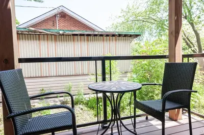 a patio with two chairs and a table on a deck at ENTIRE 2 BEDROOM APARTMENT UPTOWN WATERLOO - e2 in Waterloo