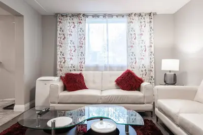 a living room with a white couch and a window at ENTIRE 2 BEDROOM APARTMENT UPTOWN WATERLOO - e1 in Waterloo