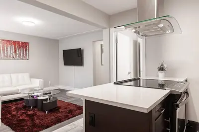 a kitchen and living room with a couch and a table at ENTIRE 2 BEDROOM APARTMENT UPTOWN WATERLOO - e1 in Waterloo