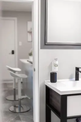 a bathroom with a white sink and a stool at ENTIRE 2 BEDROOM APARTMENT UPTOWN WATERLOO - e1 in Waterloo