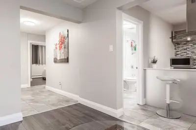 a living room with white walls and a kitchen at ENTIRE 2 BEDROOM APARTMENT UPTOWN WATERLOO - e1 in Waterloo