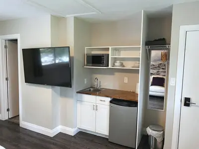 a kitchen with a sink and a tv on the wall at ENTIRE BACHELOR UNIT EN-SUITE UPTOWN WATERLOO - e5 in Waterloo