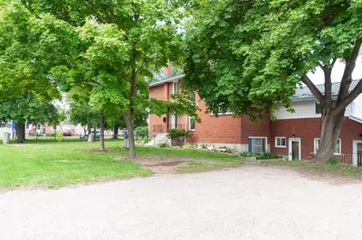 a red brick building with trees in front of it at ENTIRE BACHELOR UNIT EN-SUITE UPTOWN WATERLOO - e5 in Waterloo