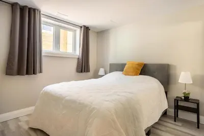 a bedroom with a bed with a yellow pillow on it at ENTIRE 2 BEDROOM APARTMENT DOWNTOWN - u1 in Kitchener
