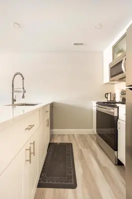 a kitchen with white cabinets and a sink and a stove at ENTIRE 2 BEDROOM APARTMENT DOWNTOWN - u1 in Kitchener