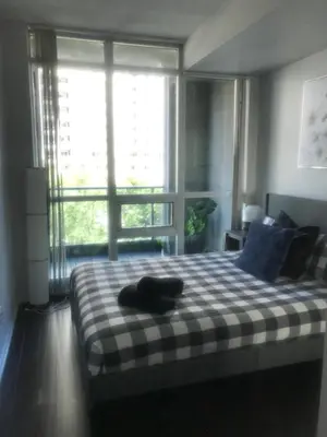 a bedroom with a bed with a large window at Executive 1 Bedroom Condo sleeps 2 in Toronto