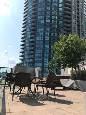 a patio with chairs and a table and a building at Executive 1 Bedroom Condo sleeps 2 in Toronto