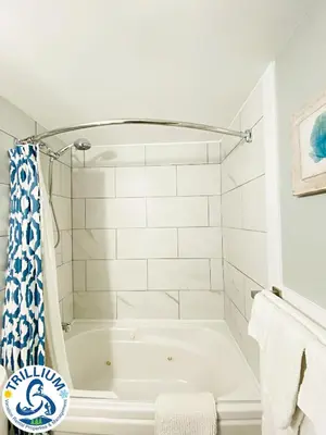 a white bath tub in a bathroom with white tiles at Slopeside Blue Mountain Condo - Wifi, Linens/Towels, Ski In/Out in Blue Mountains