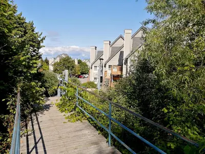 a wooden walkway leading down to a street with houses at Slopeside Blue Mountain Condo - Wifi, Linens/Towels, Ski In/Out in Blue Mountains