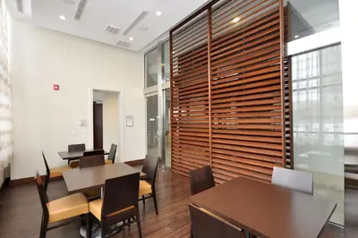 a dining room with tables and chairs and a large wooden wall at Royal Stays Furnished Apartments - Square One in Mississauga