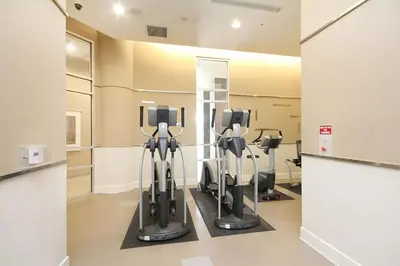a gym with treadmills and ellipticals in a room at Royal Stays Furnished Apartments - Square One in Mississauga