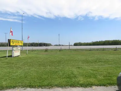 a sign in a field next to a road at Newburg Inn Motel in New Hamburg
