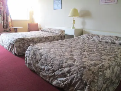a hotel room with two beds and a table at Newburg Inn Motel in New Hamburg