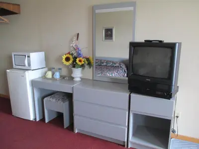 a room with a tv and a dresser with a dresser at Newburg Inn Motel in New Hamburg