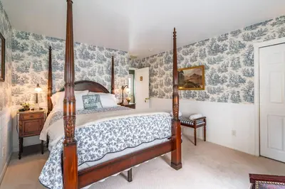 a bedroom with a canopy bed and blue and white wallpaper at Abacot Hall Bed & Breakfast in Niagara on the Lake