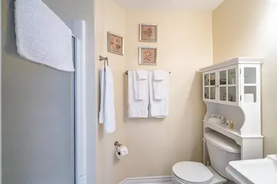 a white bathroom with a toilet and a sink at Abacot Hall Bed & Breakfast in Niagara on the Lake
