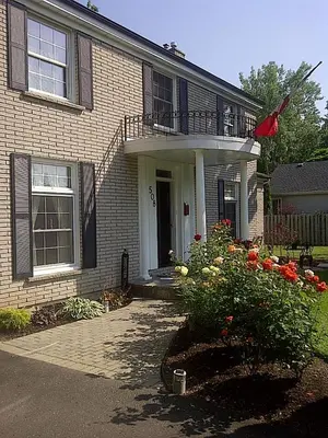 a brick house with a balcony and flowers at Abacot Hall Bed & Breakfast in Niagara on the Lake