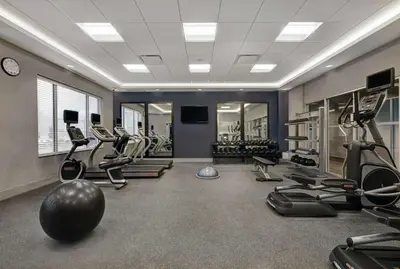 a gym with several treadmills and elliptical machines at Hampton Inn Peterborough in Peterborough