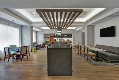 a lobby with a bar and tables and chairs at Hampton Inn Peterborough in Peterborough