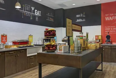 a kitchen with a counter with food on it at Hampton Inn Peterborough in Peterborough