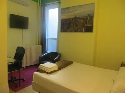 a bedroom with a bed and a desk and a window at Keppner Guesthouse in Toronto