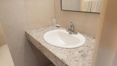 a white sink in a bathroom with a mirror at Clarkson Village Motel, 1815 Lakeshore Rd West Mississauga in Mississauga