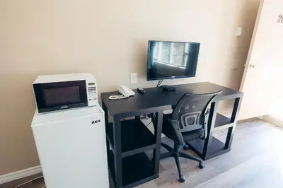 a black desk with a microwave and a television at Clarkson Village Motel, 1815 Lakeshore Rd West Mississauga in Mississauga