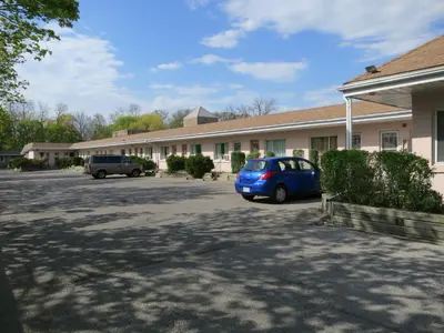 a blue car parked in front of a building at Clarkson Village Motel, 1815 Lakeshore Rd West Mississauga in Mississauga