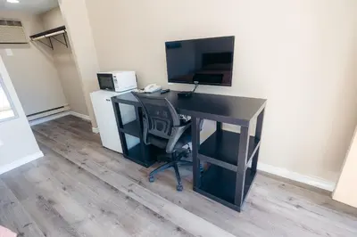 a desk with a computer and a monitor and a chair at Clarkson Village Motel, 1815 Lakeshore Rd West Mississauga in Mississauga