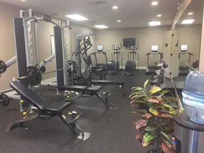 a gym with several treadmills and machines in a room at Rocky Crest Golf Resort in MacTier