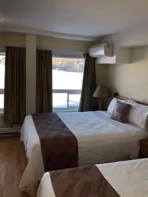 a hotel room with two beds and a window at Muskoka Lakes Hotel and Resorts in Port Carling