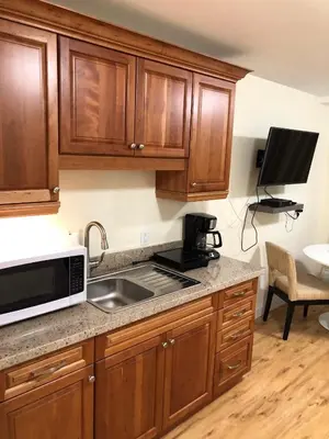 a kitchen with wooden cabinets and a sink and a microwave at Muskoka Lakes Hotel and Resorts in Port Carling