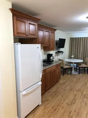 a kitchen with wooden cabinets and a white refrigerator at Muskoka Lakes Hotel and Resorts in Port Carling