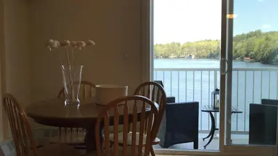 a table with chairs and a vase with flowers on it at Muskoka Lakes Hotel and Resorts in Port Carling