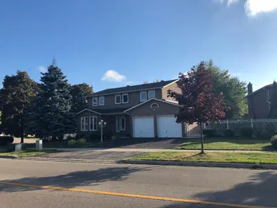 a house with a white garage on a street at Comfort Stays near Toronto Airport in Mississauga