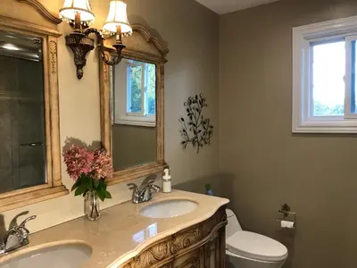 a bathroom with a sink and a toilet and a mirror at Comfort Stays near Toronto Airport in Mississauga