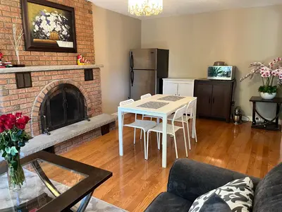 a living room with a table and a fireplace at Comfort Rooms Near Toronto Airport in Mississauga