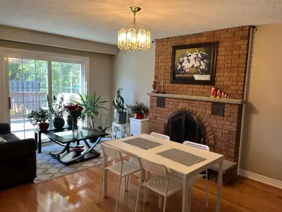 a living room with a table and a fireplace at Comfort Rooms Near Toronto Airport in Mississauga