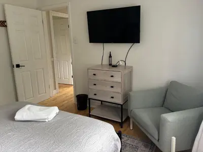 a bedroom with a bed and a couch and a television at Clearbrooke Gem- Bright Private Bedroom close to YYZ in Toronto