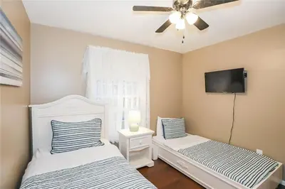 a bedroom with two beds and a flat screen tv at Dorchester Cottage Licence 044-2022 in Niagara on the Lake