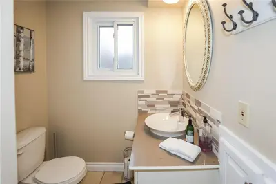 a bathroom with a sink and a toilet and a mirror at Dorchester Cottage Licence 044-2022 in Niagara on the Lake