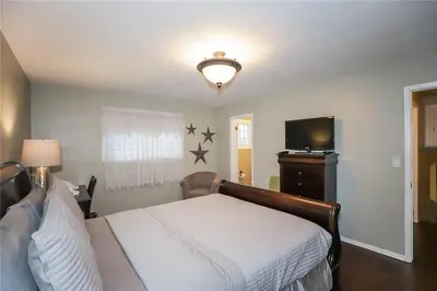 a bedroom with a bed and a flat screen tv at Dorchester Cottage Licence 044-2022 in Niagara on the Lake