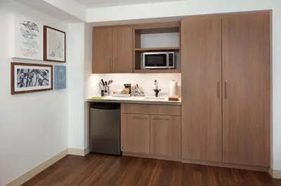 a kitchen with wooden cabinets and a sink and a microwave at Element Toronto Airport in Mississauga