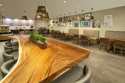 a restaurant with a large wooden table and chairs at Element Toronto Airport in Mississauga