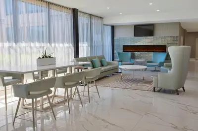 a dining room with a table and chairs and a fireplace at Element Toronto Airport in Mississauga