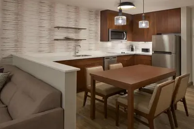 a kitchen with a table and a refrigerator and a dining room at Residence Inn by Marriott Toronto Mississauga Southwest in Mississauga