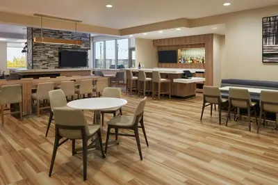 a waiting room with tables and chairs and a bar at Residence Inn by Marriott Toronto Mississauga Southwest in Mississauga