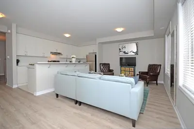 a living room with two couches and a kitchen at Royal Stays Townhome Collection - 3 Bedroom Townhome in Oakville in Oakville