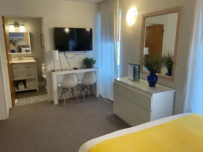a bedroom with a bed and a desk and a television at Paradise Inn On the Beach in Port Elgin