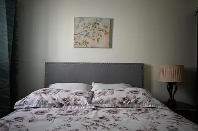 a bedroom with a bed with a flowered comforter at Metropolitan Suite in Niagara Falls